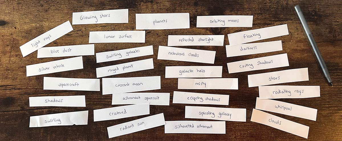 Photo of 30 small strips of white paper against a wooden surface. Each piece of paper has a word or phrase written on it. A pen is in the top right corner.