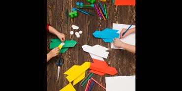 Children's hands and craft material working at a table