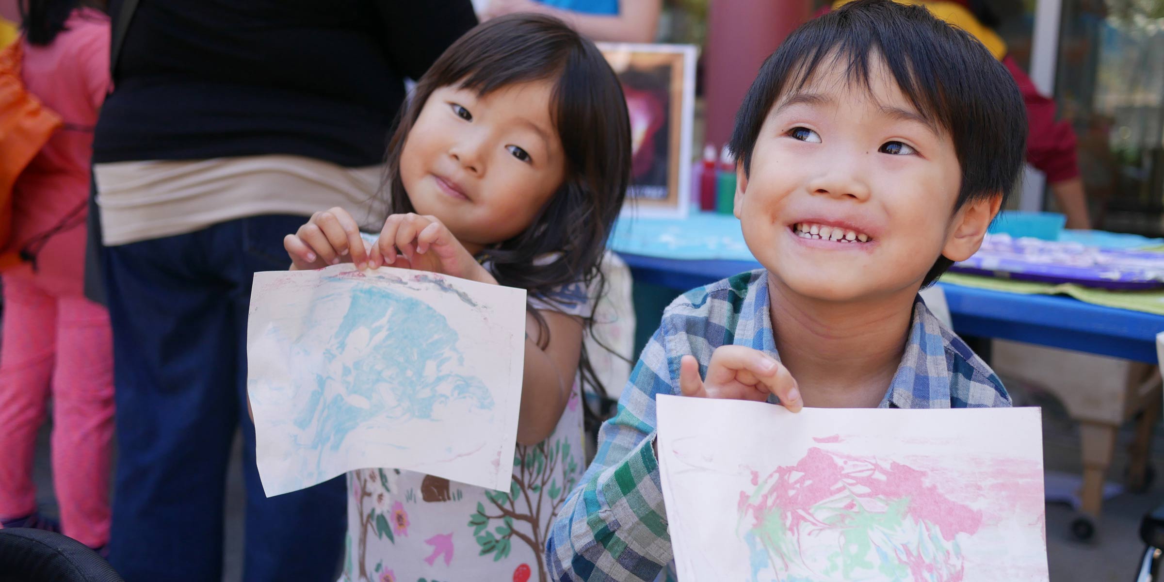 Young boy and girl showing of their artwork