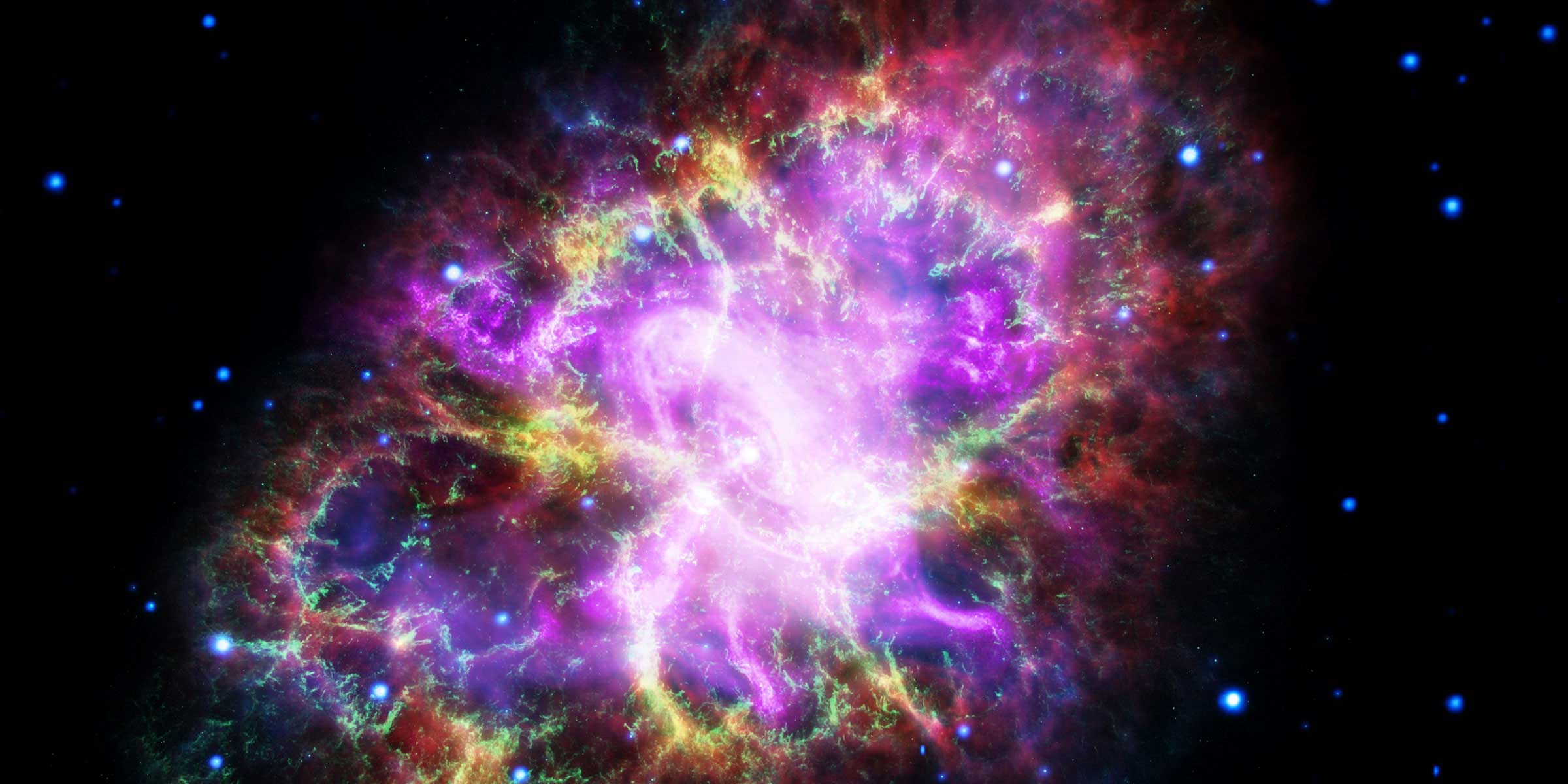 Combined telescope images of the Crab Nebula displayed in red, yellow, green, ultraviolet, and X-ray light