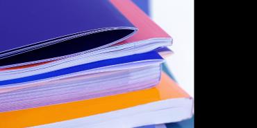 A stack of colorful paperback books and papers
