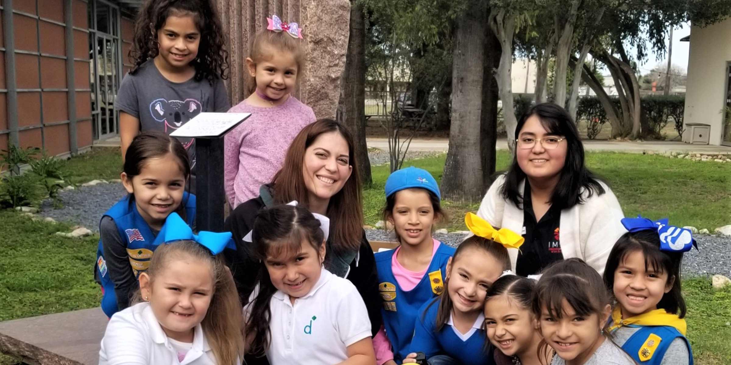 Children posing together with a teacher outside