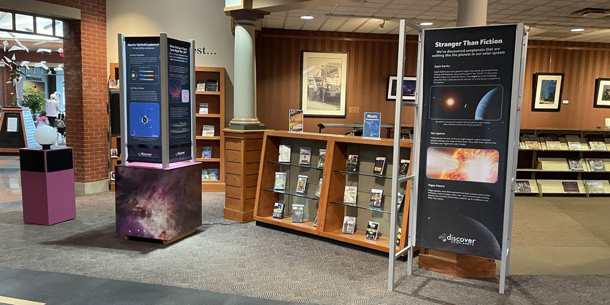 An open room shows a series of small stations, with text on one large panel and several smaller areas within the exhibition.