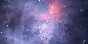 An image of a young star-forming region filled with wispy blue, grey, green, and red nebulosity that is brightest towards the centre and fainter towards the edges, especially in the top left corner and on the right side. Thousands of stars are seen sprinkled across the field, concentrated towards the center, and the brightest stars show the eight spikes due to diffraction that are characteristic of Webb images.