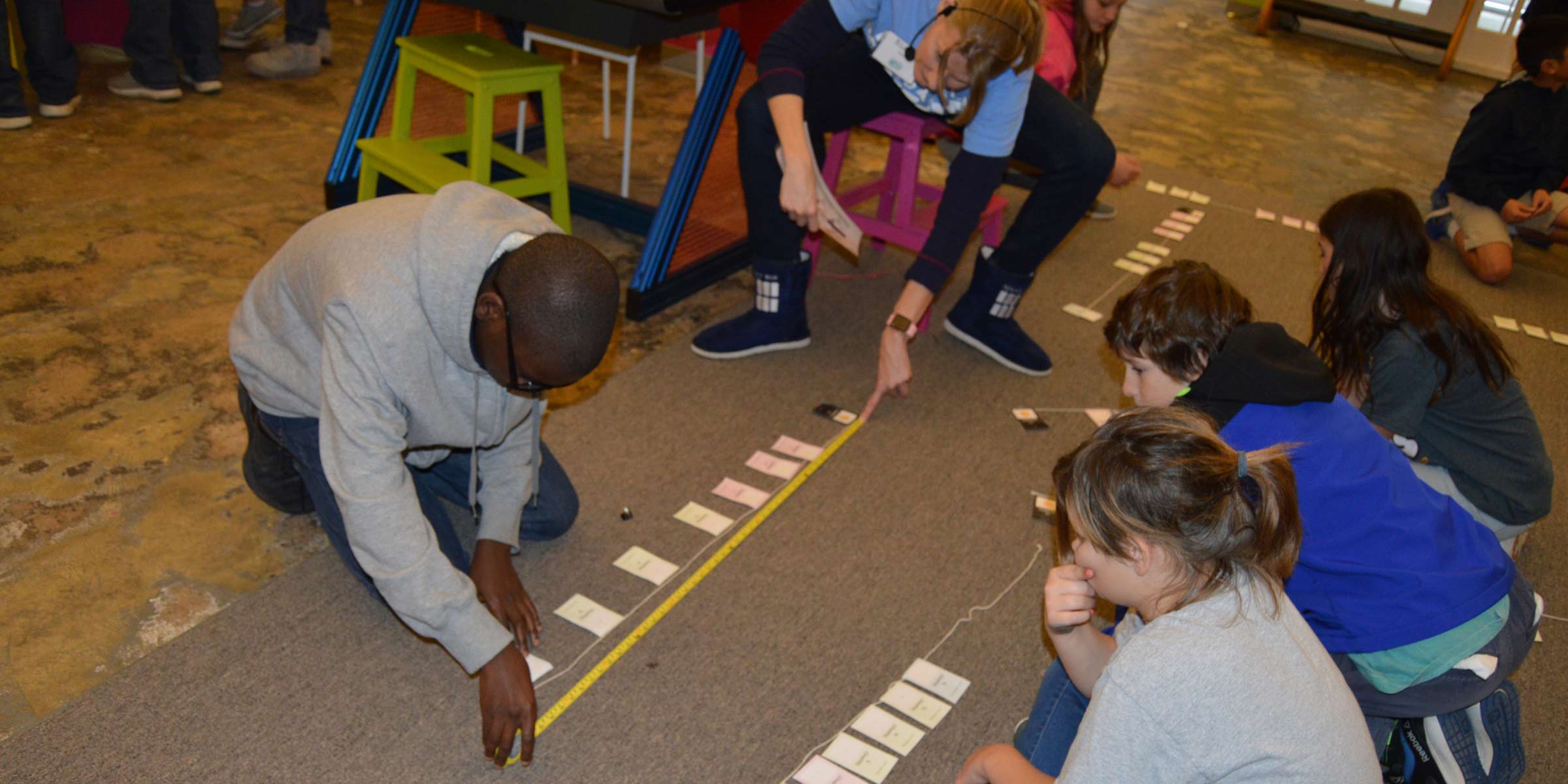 Kids working on an activity with a measuring tape