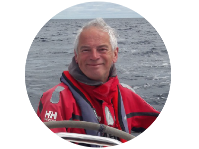 A man with grey hair befitting his years, engaging in his favorite pastime outside of Astronomy, sailing around the coast of Ireland.